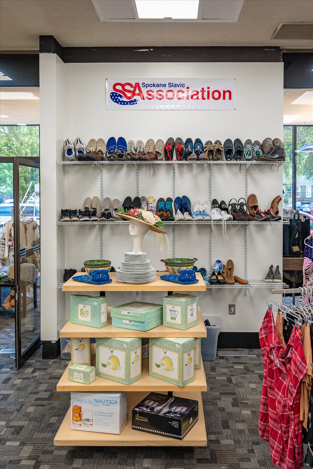 A shelf of donated shoes beneath a Spokane Slavic Association banner at the International Resource Center.