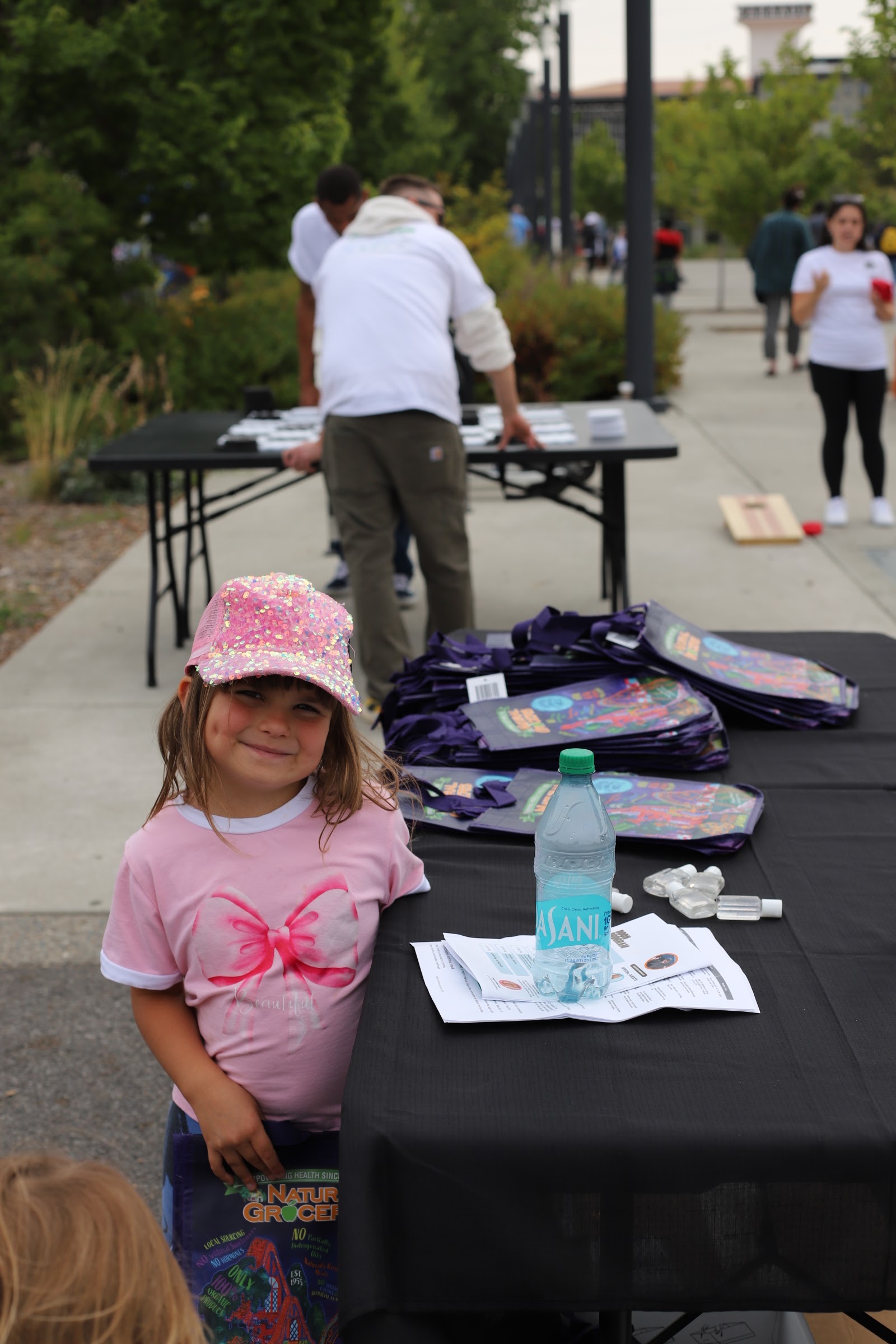 A volunteer distributing bags to community members at an SSA outreach event.